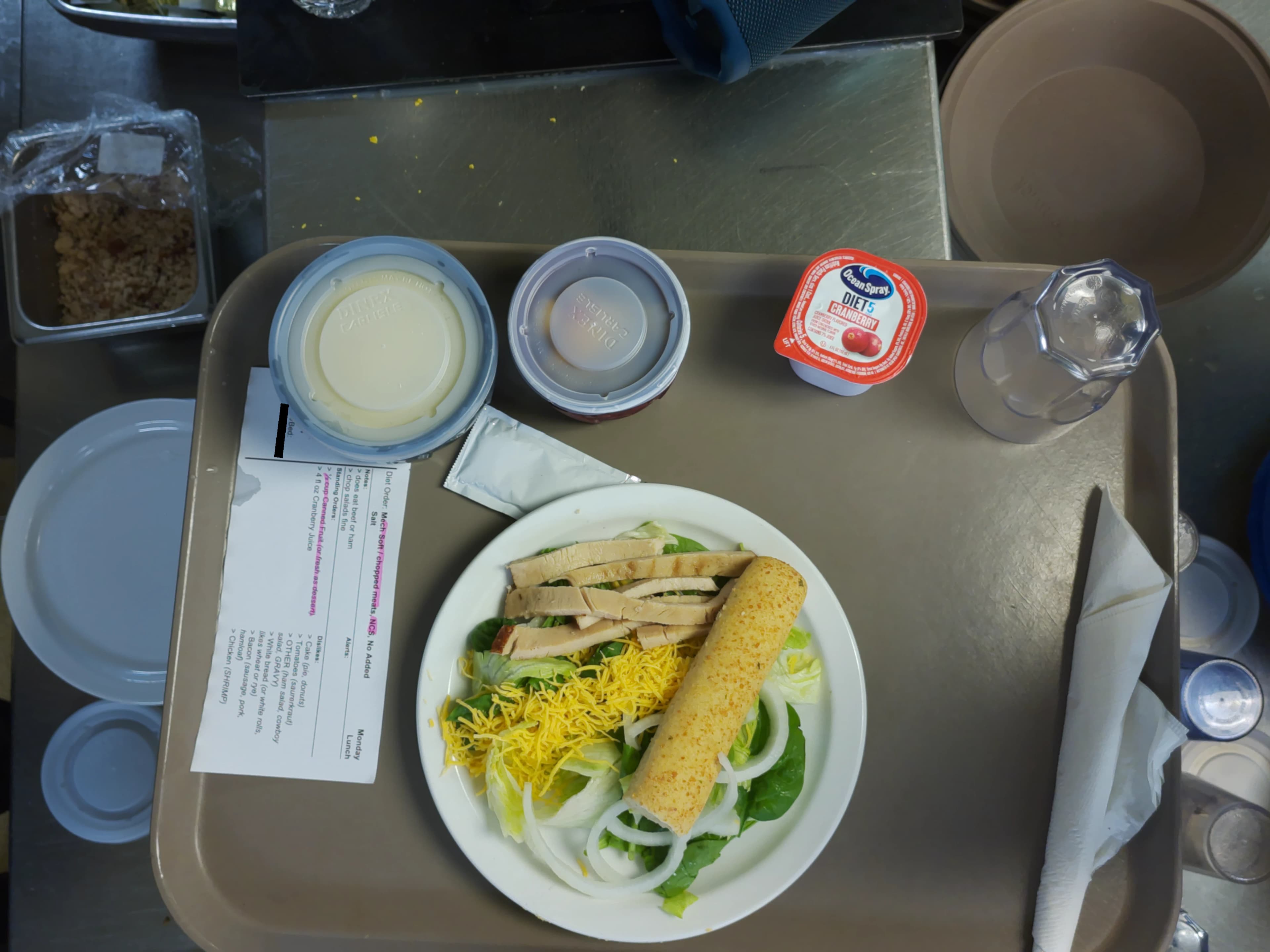 Tray photo: modified-texture ticket with long chicken strips, raw salad, onion, and a whole breadstick.